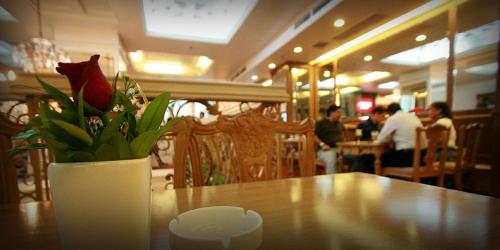 a vase of flowers on a table in a restaurant at Networld Hotel Spa and Casino in Manila