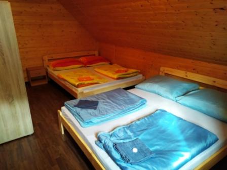 two twin beds in a wooden room at Penzion Zátiší in Komorní Lhotka