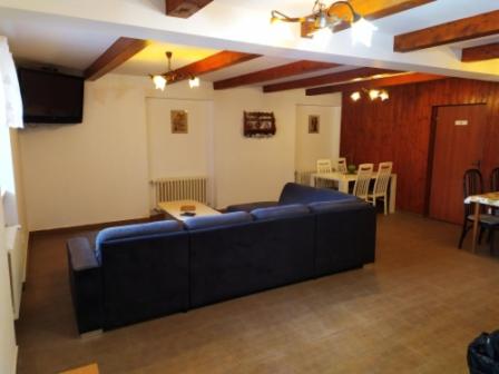 a living room with a blue couch and a table at Penzion Zátiší in Komorní Lhotka