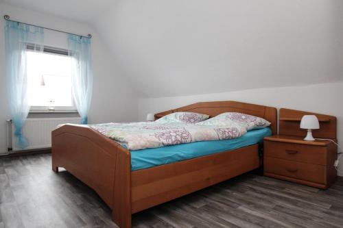 Schlafzimmer mit einem Bett und einem Fenster in der Unterkunft Ferienhaus Olenbrook in Cuxhaven