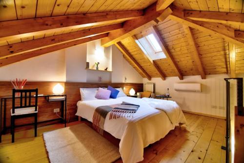 ヴァレーゼにあるBed & Breakfast Le Due Gの木製の天井が特徴のベッドルーム1室(大型ベッド1台付)
