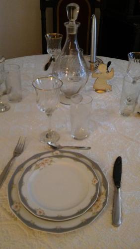 a table with a plate and glasses on a table at CHRYSSA - ΧΡΥΣΑ in Patra