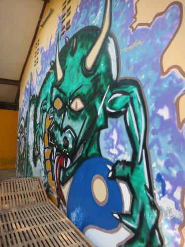 a wall with a painting of a green dragon on it at Pan's Place in Vang Vieng