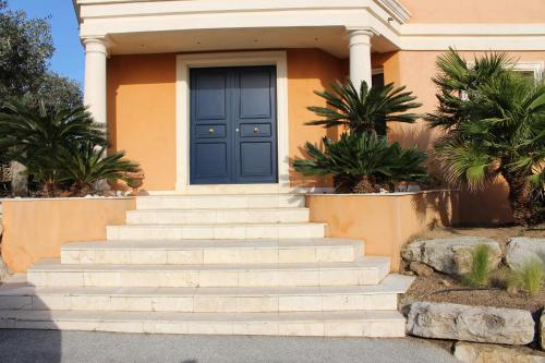 une maison avec une porte bleue et des escaliers dans l'établissement La Romarine, à Sainte-Maxime