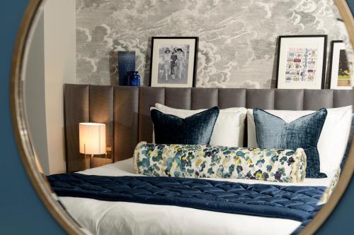 a mirror reflecting a bed with blue pillows at Gonville Hotel in Cambridge