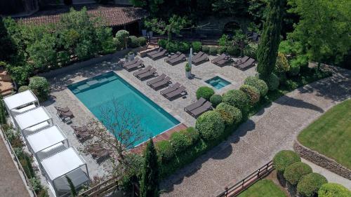 an overhead view of a swimming pool with chaise lounge chairs and trees at Hôtel Montmorency & Spa in Carcassonne