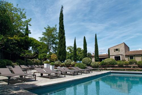a pool with lounge chairs and a house at Hôtel Montmorency & Spa in Carcassonne