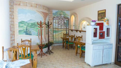 a dining room with tables and chairs and a painting on the wall at Hotel TEX Club in Botoşani
