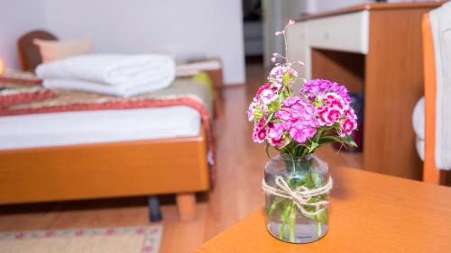 a vase filled with flowers sitting on a table at Hotel TEX Club in Botoşani