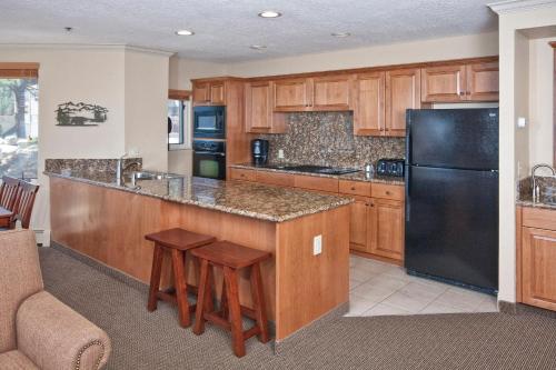 a kitchen with a black refrigerator and wooden cabinets at Holiday Inn Club Vacations - Tahoe Ridge Resort in Stateline