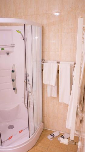 a bathroom with a shower and white towels at Hotel TEX Club in Botoşani