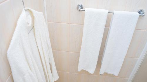 a bathroom with white towels hanging on a wall at Hotel TEX Club in Botoşani