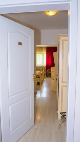 a room with a white door and a living room at Hotel TEX Club in Botoşani