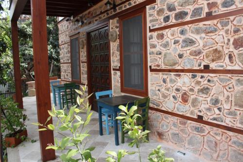 a stone house with two blue chairs on a patio at Hotel Villa Turka in Alanya