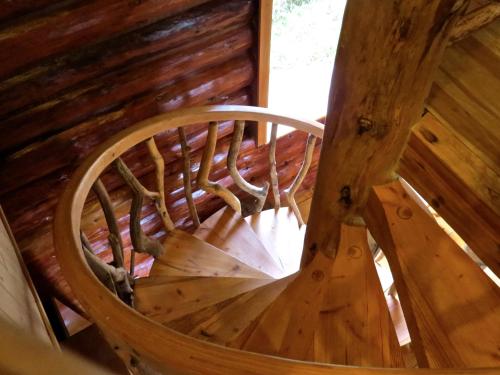 an overhead view of a wooden spiral staircase in a cabin at Handsome Dan's at Otter Point in Sooke