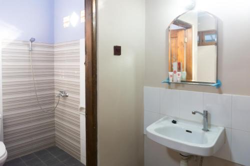 een witte badkamer met een wastafel en een spiegel bij Super OYO 942 Srikandi Hotel in Pacitan