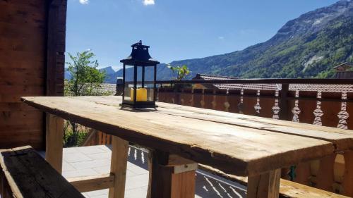 einen Holztisch mit einer Lampe auf dem Balkon in der Unterkunft Les Picaillons - Le gîte in Les Villards-sur-Thônes