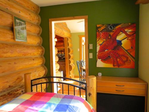 a bedroom with a bed and a log wall at Handsome Dan's at Otter Point in Sooke