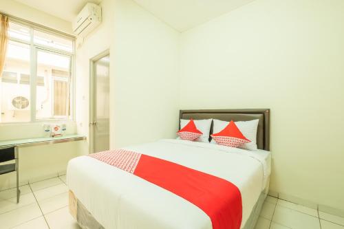 a bedroom with a bed with red and white pillows at OYO Collection O 818 Micasa Residence in Bandung