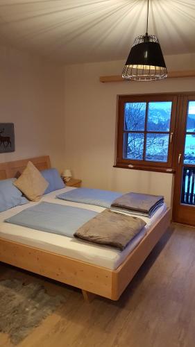 ein großes Bett in einem Schlafzimmer mit einem Kronleuchter in der Unterkunft Holiday House Spanner in Tauplitz