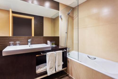 uma casa de banho com um lavatório e uma banheira em Hotel Sercotel Portales em Logroño
