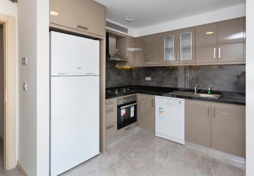 a kitchen with a white refrigerator and a sink at Princess Residence in Istanbul