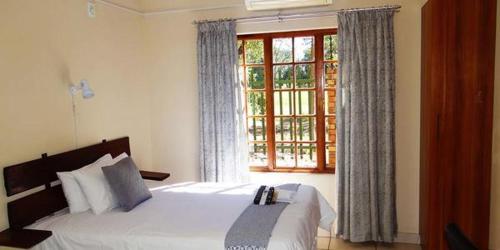 a bedroom with a large bed and a window at Lepha Guest House in Onverwacht