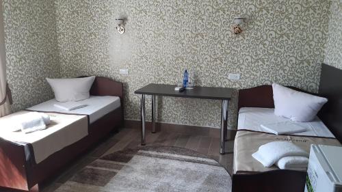 a room with two beds and a table in it at Motel Xameleon in Voznesensk