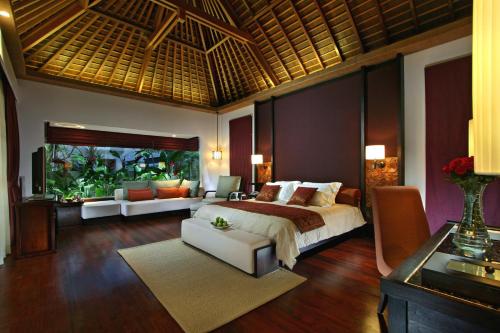 a bedroom with a bed and a large aquarium at The Royal Santrian in Nusa Dua
