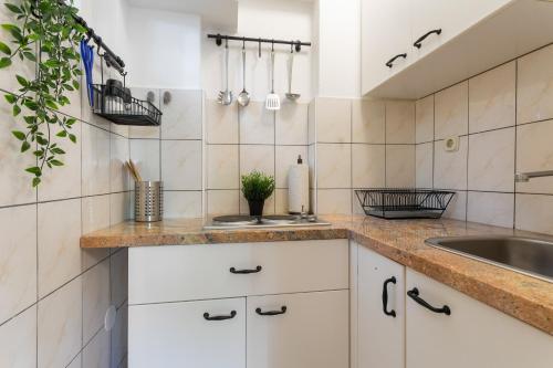 a kitchen with white cabinets and a sink at Central View Apartment in Hvar