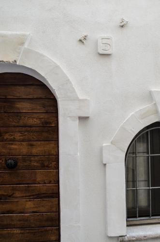 a building with a wooden door and two windows at La casa del geko in Vieste