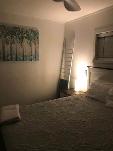 a bedroom with a bed and a painting on the wall at Bar Harbor in Papamoa
