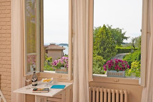 a room with a table and a window with flowers at VALLE FIORITA 42 - Lake view Studio in Gardone Riviera