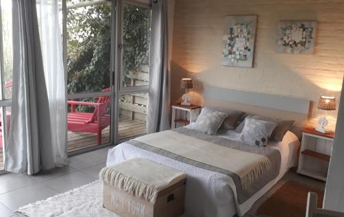 a bedroom with a bed and a balcony at Dejeps in Punta Del Diablo