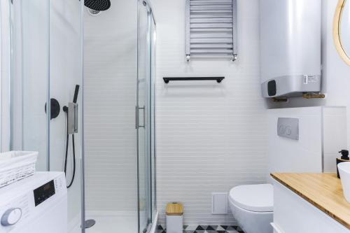 a white bathroom with a shower and a toilet at Apartament IGO OLD TOWN in Gdańsk