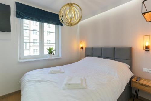 a bedroom with a large white bed with a window at Apartament IGO OLD TOWN in Gdańsk