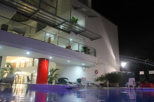 a building with a swimming pool at night at Hotel Atrium Plaza in Barranquilla