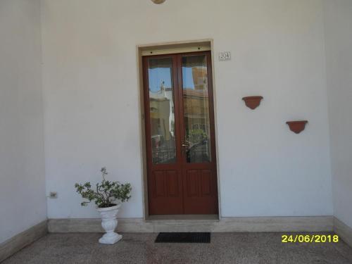 a door to a building with a plant in front at Casa Elisa in Ruffano