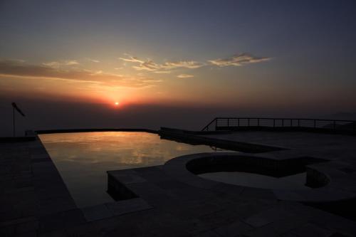 a sunset over a pool with the number on it at Chandragiri Hills Resort Kathmandu-Luxury in the Clouds in Thānkot