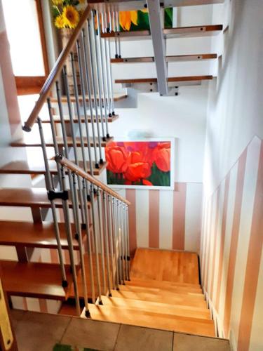 a staircase with a painting of flowers on the wall at Ca' Mia Ca' Tua in La Loggia