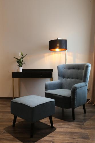 a blue chair and a ottoman next to a desk at LETO Boutique Hotel Zugdidi in Zugdidi