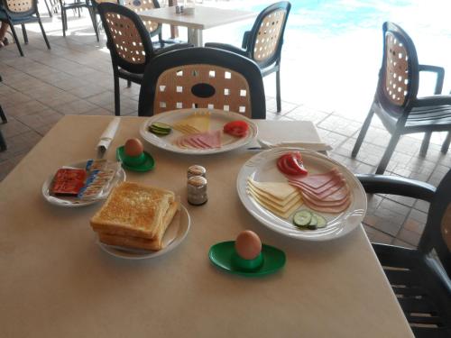 uma mesa com pratos de comida em cima em Kkaras Hotel 3 Star em Ayia Napa