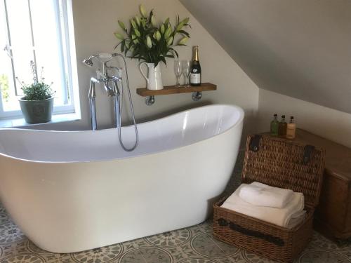 a bathroom with a white bath tub in a attic at The Old Dower House in Whitchurch