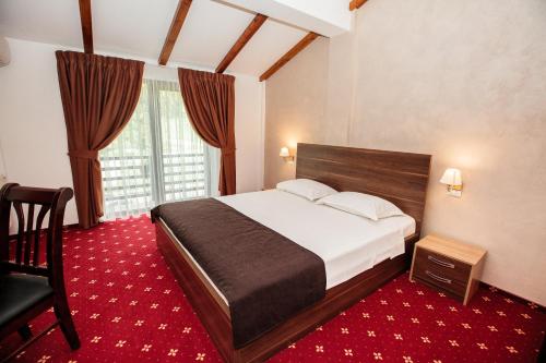 - une chambre avec un lit, une chaise et une fenêtre dans l'établissement Magic Garden by Vlăduț, à Bacău