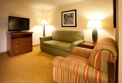 a living room with a couch and a television at Country Inn & Suites by Radisson, Knoxville at Cedar Bluff, TN in Knoxville