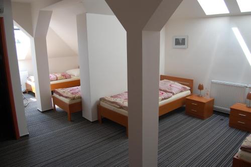 a room with two beds and two tables in it at Penzion Jarka in Bratislava