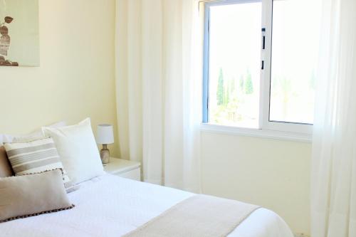 Habitación blanca con cama y ventana en Regina Gardens, Phase 1 (Sea View) en Pafos