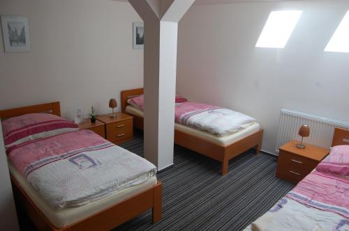 a bedroom with two beds and two night stands at Penzion Jarka in Bratislava