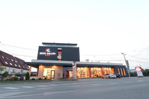 a building with a clock on it on a street at Hotel Galaxy in Timişoara