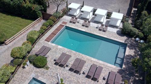 vista sulla piscina con sedie a sdraio e sidx. di Hôtel du Château & Spa - Teritoria a Carcassonne